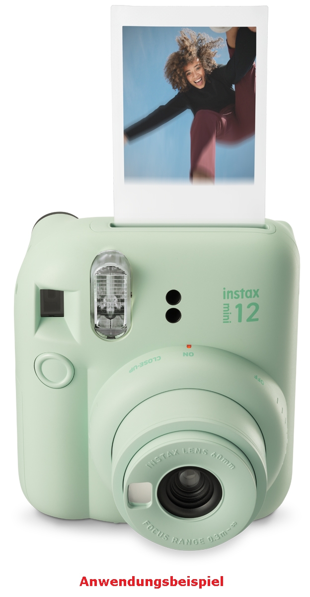 Fujifilm Instax Mini 12 Sofortbildkamera vor weißem Hintergrund mit direktem Blick auf das ausgedrehte Objektiv mit der Aufschrift „INSTAX LENS 60mm“, den integrierten vertikalen Blitz, den kleinen Selfie-Spiegel neben der Linse und den dezenten Produktau