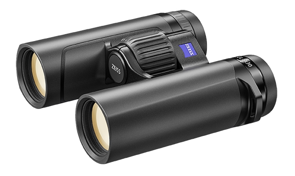 Ein kompaktes, schwarzes ZEISS Victory SFL 8x30 Fernglas, schräg von vorne und oben fotografiert auf einem weißen Hintergrund. Die beiden Frontlinsen im Vordergrund weisen eine helle Antireflexbeschichtung auf. Auf der Brücke prangt das quadratische blaue