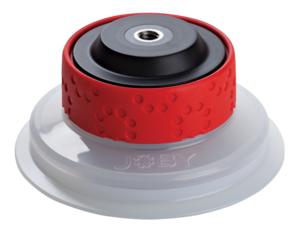 Ein runder Joby Saugnapf (Suction Cup) mit transparenter Silikonbasis und einem auffälligen, strukturierten roten Drehring zur Vakuum-Verriegelung, leicht schräg von oben auf weißem Hintergrund fotografiert, mit einem zentralen Gewindeanschluss an der Obe