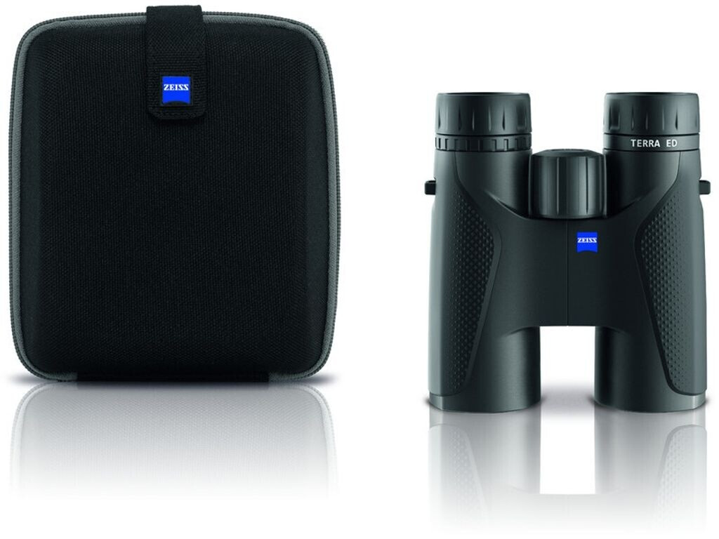 Das komplett schwarze ZEISS Terra ED Dachkant-Fernglas steht in der Frontansicht rechts neben der dazugehörigen, geschlossenen schwarzen Fernglastasche (Hartschalen-Etui) vor einem rein weißen Hintergrund. Am rechten Gehäusering des Fernglases ist die wei