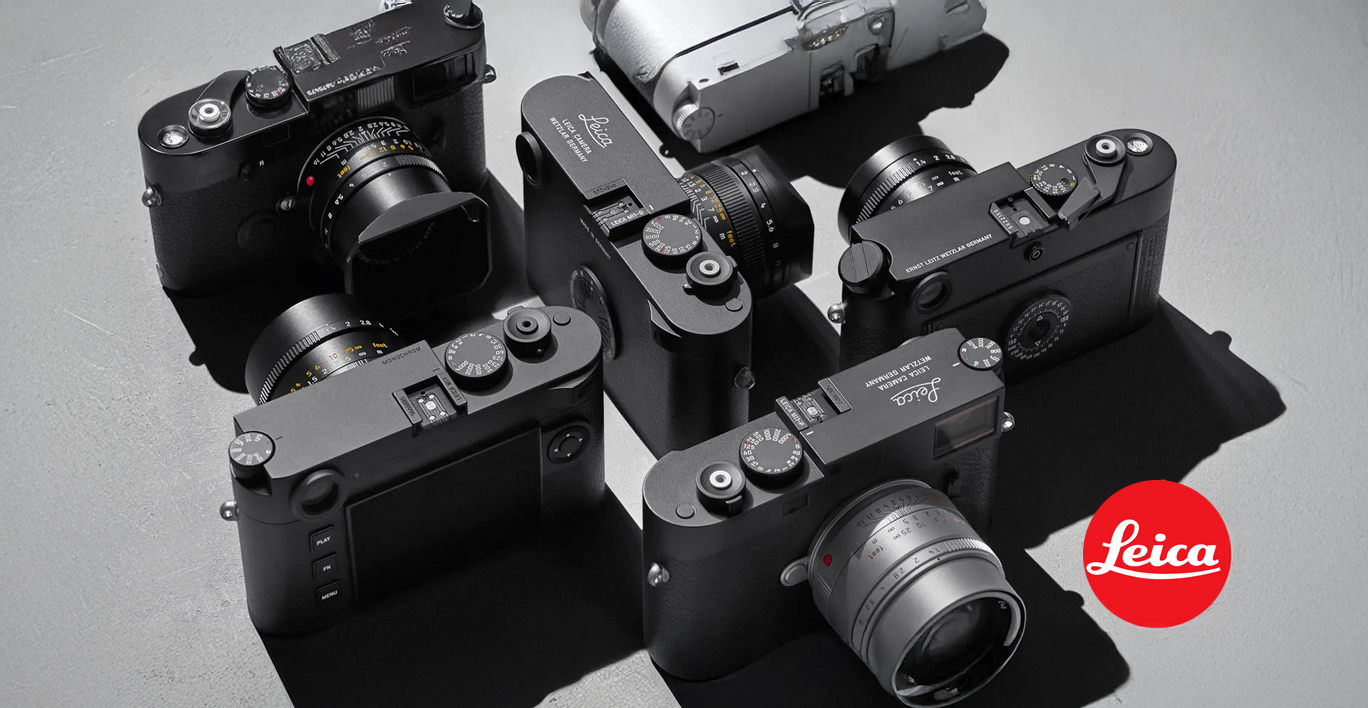 Mehrere Leica Kameras mit Objektiven in Draufsicht arrangiert, daneben das rote Leica Logo.