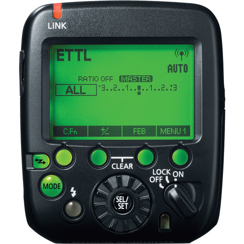Detailansicht der Rückseite des schwarzen Canon ST-E3-RT Speedlite Transmitters mit eingeschaltetem, grün beleuchtetem LCD-Display, E-TTL-Anzeige und ergonomischem Tastenlayout zur Funk-Blitzsteuerung vor weißem Hintergrund.