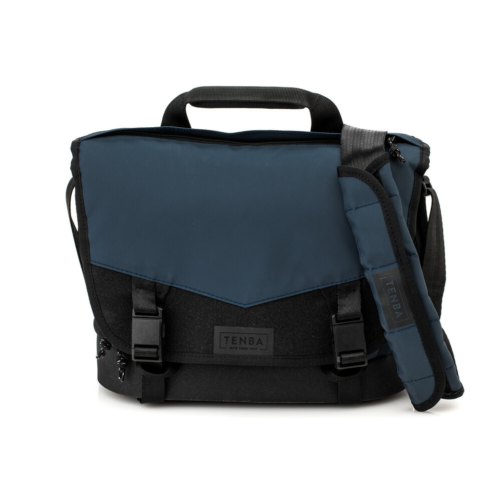 Eine geschlossene, blau-schwarze Tenba DNA Messenger-Kameratasche in der Frontalansicht, freigestellt auf weißem Hintergrund. Die große, wetterfeste Taschenklappe ist im oberen Bereich in einem dunklen Marineblau gehalten, während der untere Teil sowie di