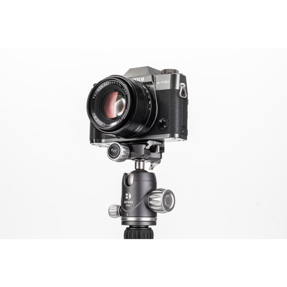 Schräge Frontansicht einer schwarzen Fujifilm X-T3 Systemkamera vor weißem Hintergrund mit montiertem Festbrennweiten-Objektiv, befestigt auf einem dunkelgrauen Benro VX25 Stativ-Kugelkopf samt Arca-Swiss-Schnellwechselbasis.
