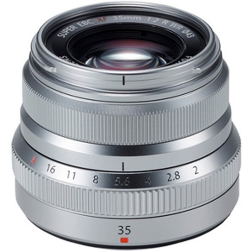 Silberfarbenes Fujifilm-Festbrennweitenobjektiv mit geriffelten Einstellringen, Blendenring und sichtbarer Blendenskala auf weißem Hintergrund.