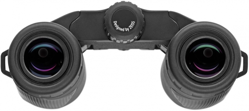 Die Okularseite eines schwarzen ZEISS Terra ED Pocket Kompaktfernglases, direkt von oben vor einem rein weißen Hintergrund fotografiert. Im Fokus stehen die beiden kreisrunden, schwarzen Okulare mit ihren Gummi-Augenmuscheln, in deren Linsenoberflächen si