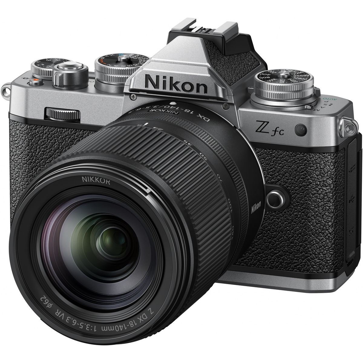Nikon Z fc spiegellose Systemkamera in Silber und Schwarz im Retro-Design, ausgestattet mit einem Nikkor Z DX 18-140mm f/3.5-6.3 VR Objektiv, freigestellt vor weißem Hintergrund.