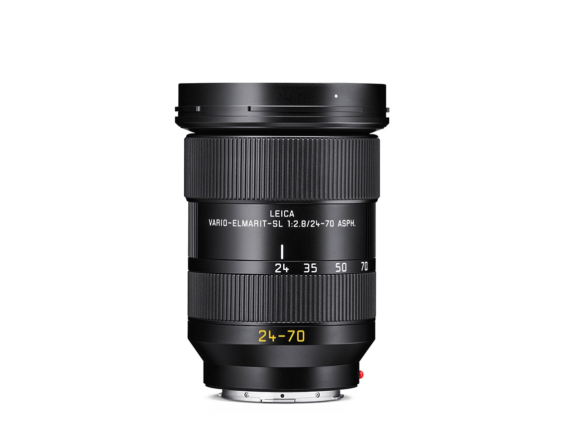 Schwarzes Leica Vario-Elmarit-SL Zoomobjektiv mit Brennweitenbereich 24–70 mm, breiten geriffelten Einstellringen und sichtbarer Brennweitenskala vor weißem Hintergrund.