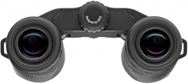 Die Okularseite eines schwarzen ZEISS Terra ED Pocket Kompaktfernglases, direkt von oben vor einem rein weißen Hintergrund fotografiert. Im Fokus stehen die beiden kreisrunden, schwarzen Okulare mit ihren Gummi-Augenmuscheln, in deren Linsenoberflächen si