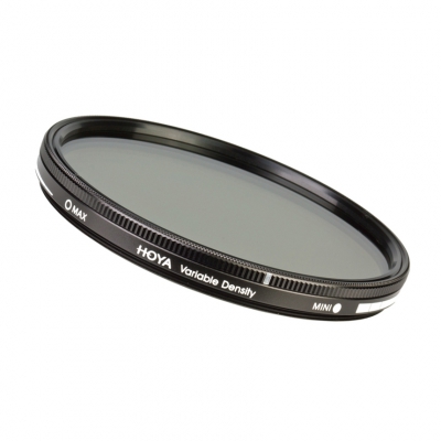 Perspektivische Seitenansicht des runden Hoya Variable Density Filters mit schwarzem Metallrahmen, geriffeltem Einstellring und sichtbaren Markierungen für Max und Mini zur stufenlosen Regulierung der Lichtmenge vor weißem Hintergrund.