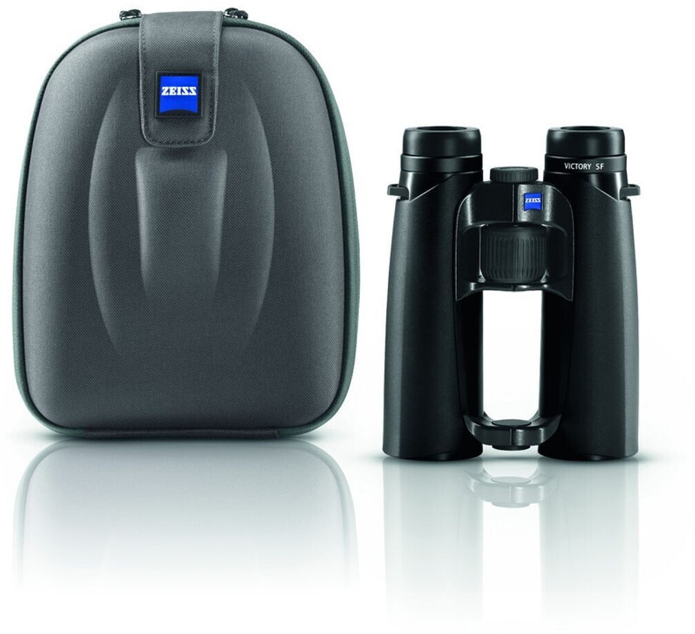 Das schwarze Premium-Dachkantfernglas ZEISS Victory SF steht in der Frontansicht rechts neben der dazugehörigen, geschlossenen dunkelgrauen Fernglastasche (Hartschalen-Etui) vor einem rein weißen Hintergrund. Am rechten Gehäusering des Fernglases ist die