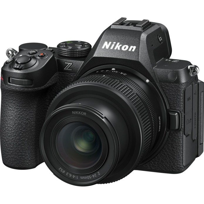 Schräge Frontansicht einer schwarzen Nikon Z5 Vollformat-Systemkamera vor weißem Hintergrund mit montiertem, extrem kompaktem NIKKOR Z 24-50mm f/4-6.3 Standard-Zoomobjektiv, sichtbarem Nikon-Markenlogo auf dem Sucherhügel und weißer Brennweitenskala am Ob