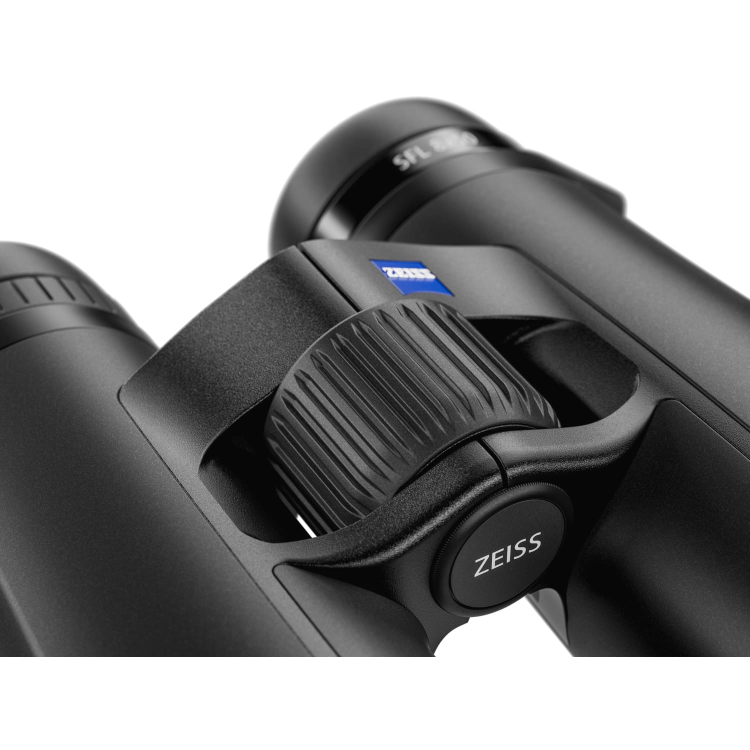 Eine Nahaufnahme des Fokussierrads und der Gehäusebrücke eines schwarzen ZEISS Victory SFL Fernglases vor weißem Hintergrund. Im Fokus steht das große, ergonomisch geformte und vertikal geriffelte Fokussierrad. Auf der oberen Gehäusebrücke ist das charakt