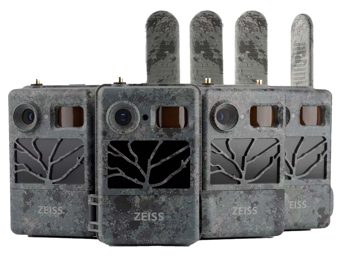 Vier Zeiss Secacam Wildkameras in Camouflage-Optik nebeneinander auf weißem Hintergrund aufgereiht, mit direktem Blick auf die Gehäusefronten inklusive Objektiv, Bewegungssensor, Infrarot-Blitz-Abdeckung, dem weißen Zeiss-Schriftzug und den nach oben geri