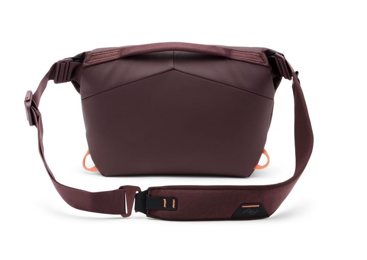 Rückansicht einer geschlossenen, weinroten Peak Design Everyday Sling V2 Kameratasche (in der Farbe Eclipse) im Querformat, flach auf einer weißen Oberfläche liegend. Gut erkennbar sind die ergonomische, minimalistisch strukturierte Rückseite, der flache