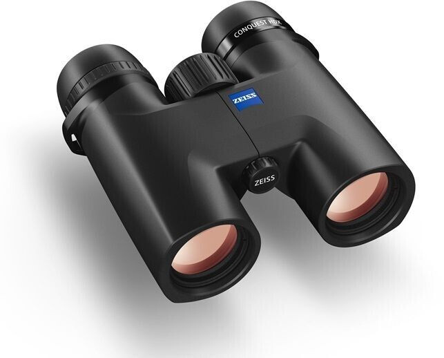 Ein schwarzes ZEISS Conquest HDX Fernglas, in einer schrägen Perspektive von vorne und oben fotografiert auf weißem Hintergrund mit einem weichen Schattenwurf. Die beiden Objektivlinsen im Vordergrund zeigen eine rötlich-orange Antireflexbeschichtung. Auf
