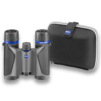Ein kompaktes, anthrazitfarbenes ZEISS Terra ED Pocket Taschenfernglas in der Frontalansicht neben seiner passenden, schwarzen Hardcase-Bereitschaftstasche, freigestellt auf weißem Hintergrund. Das Fernglas verfügt über markante blaue Zierringe unterhalb
