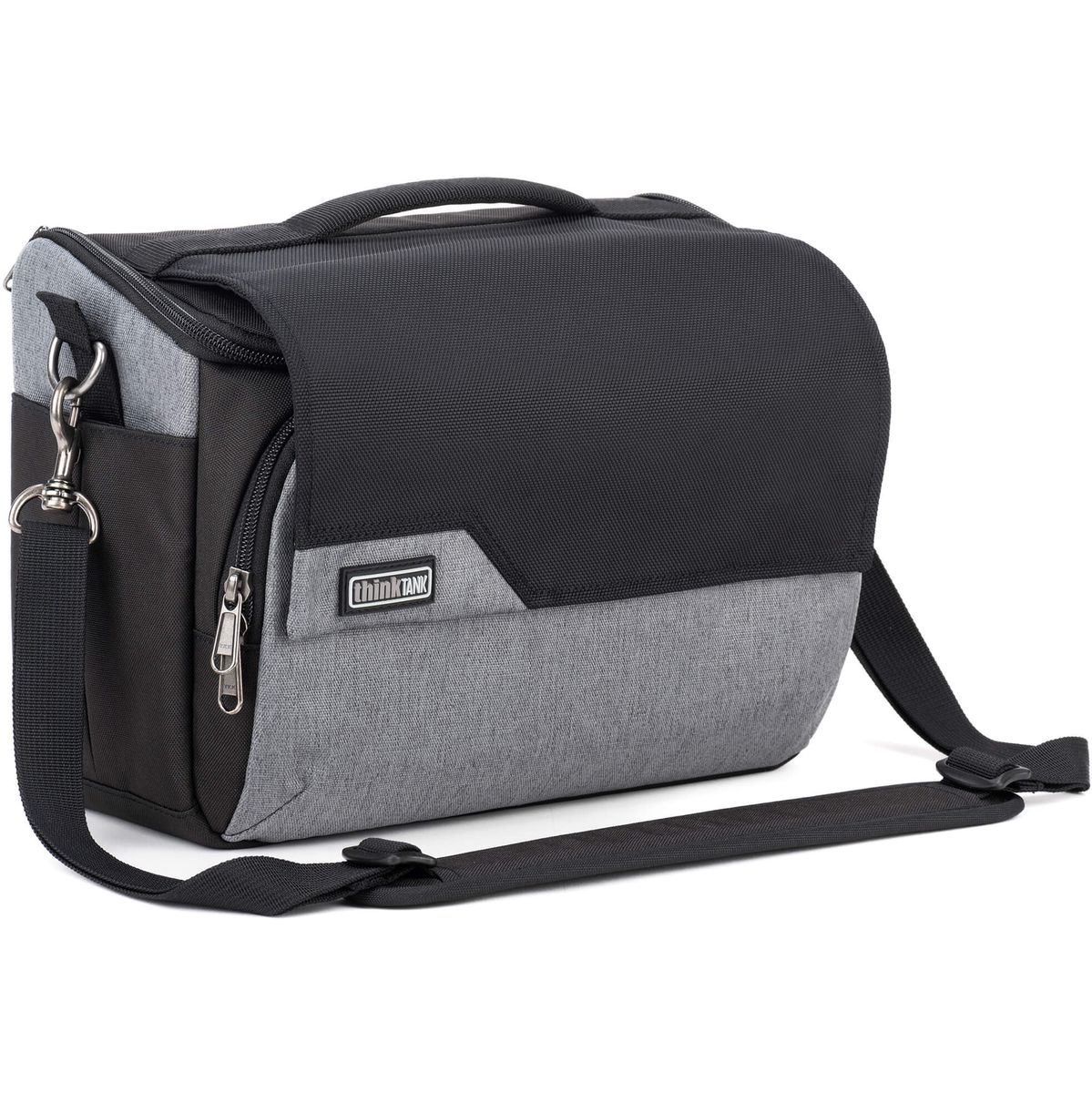 Eine zweifarbige Think Tank Mirrorless Mover Schultertasche für Kamerasysteme (Modellvariante in Cool Grey) in der Dreiviertelansicht vor weißem Hintergrund, bestehend aus einem oberen schwarzen Überschlagdeckel, einem grau melierten Unterteil sowie einem