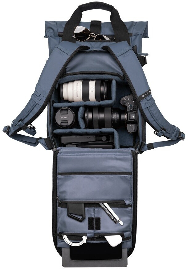 Rückansicht des komplett geöffneten WANDRD PRVKE Fotorucksacks in Blau vor weißem Hintergrund mit Blick auf das Hauptfach mit Kameraausrüstung sowie die aufgeklappte Rückwand mit Zubehörtaschen für Laptops, Kabel und Stifte.